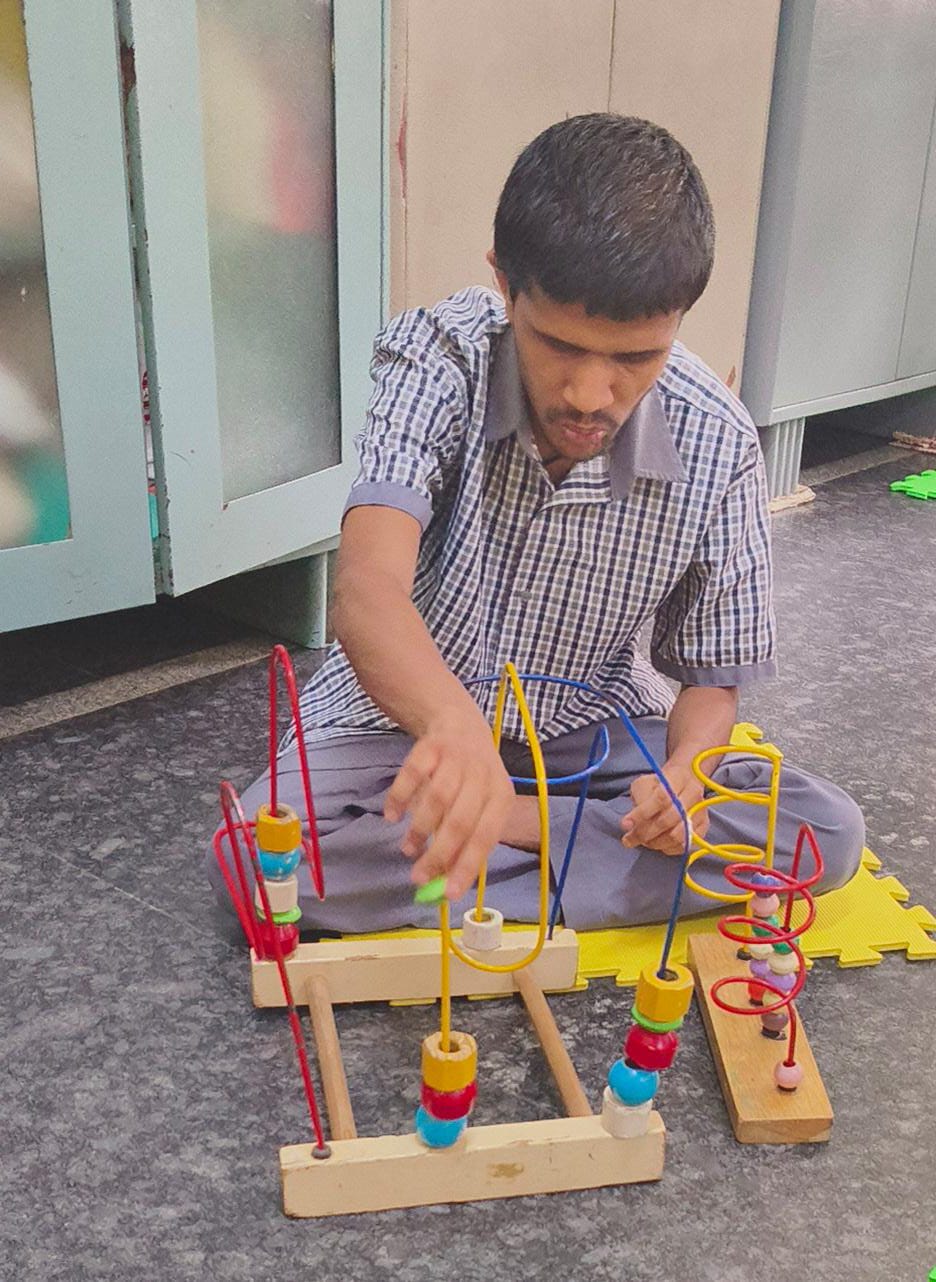 Student moving beads along a wooden therapy maze